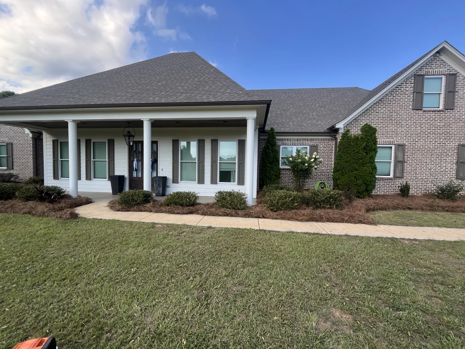 Fresh sod and pine-straw beds at a columned brick home in Oxford MS